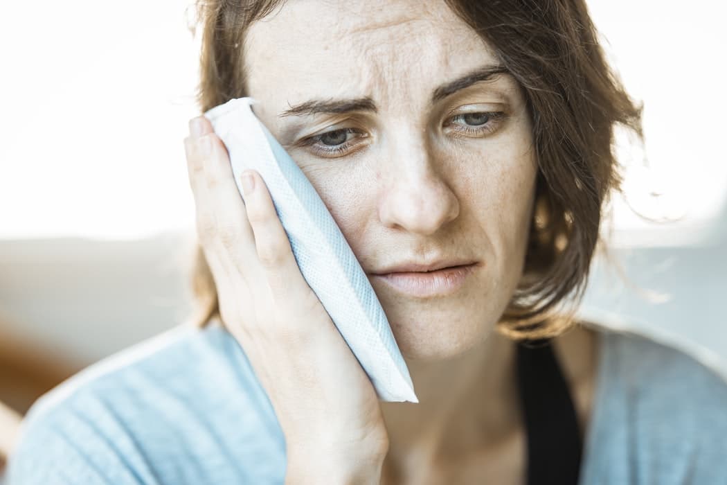Woman with an ice pack on her ear.