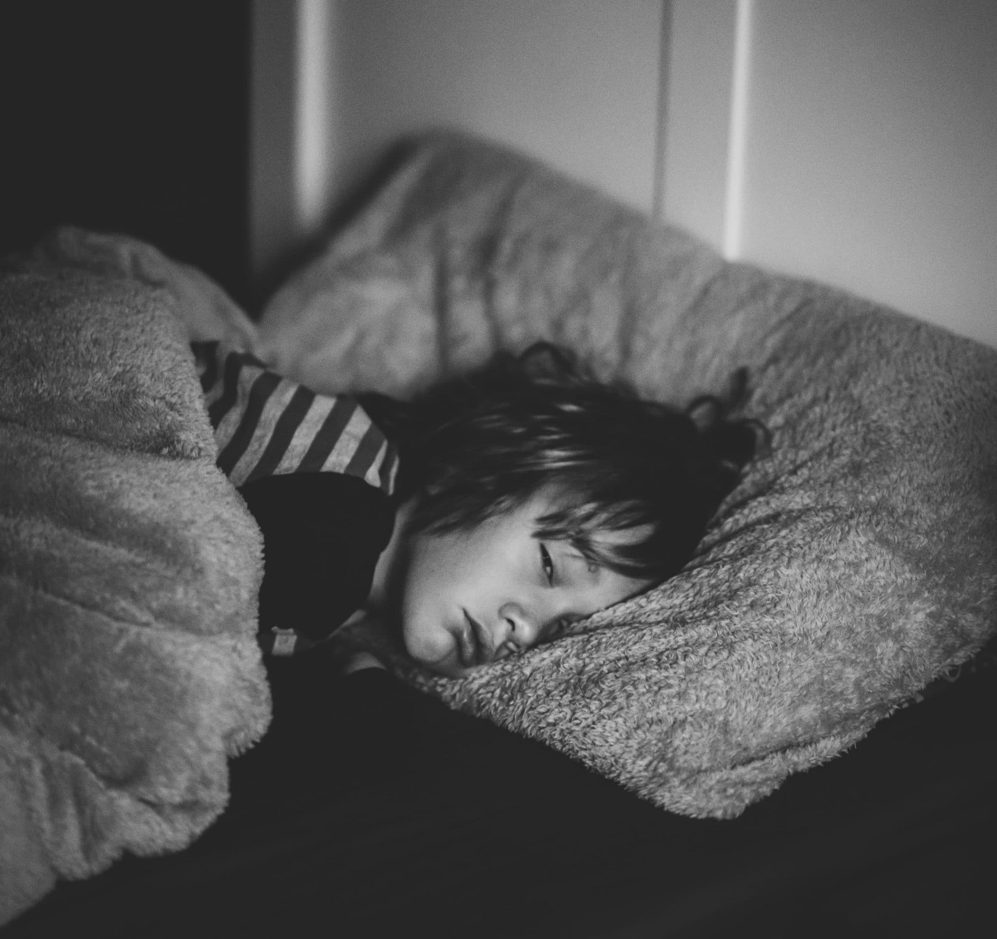 Little girl trying to sleep but her eyes are open