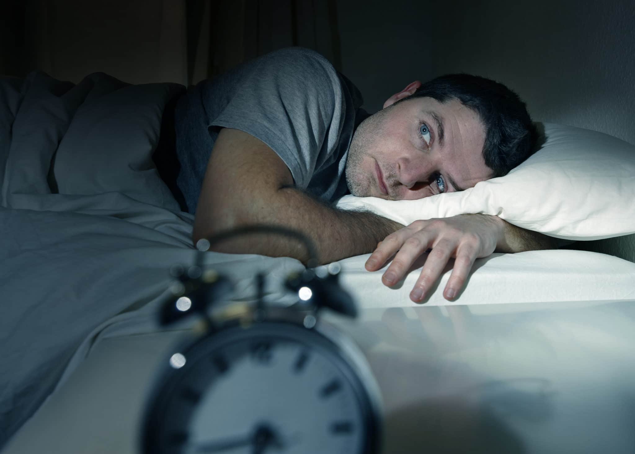 man in bed eyes opened suffering insomnia and sleep disorder