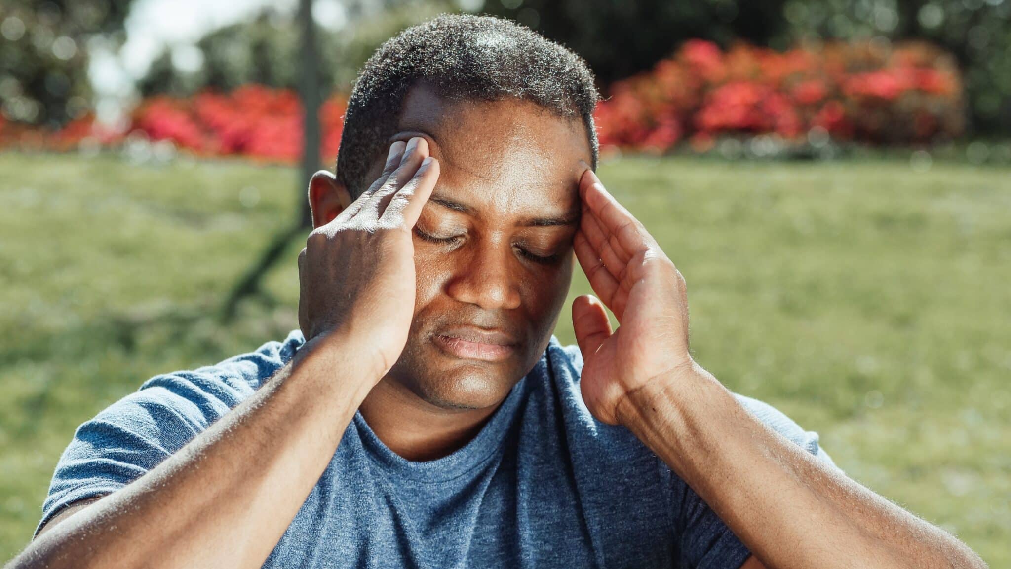 Man with a headache rubbing his temples.