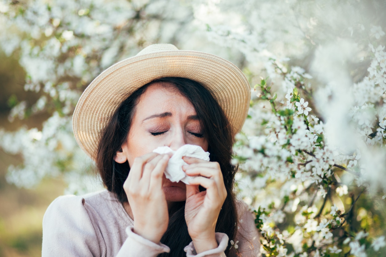 Woman sneezing around flowers