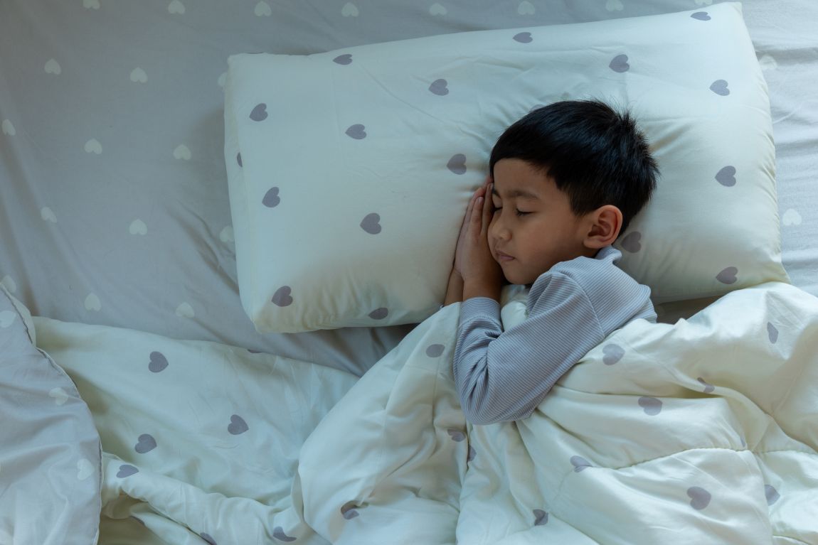 Pediatric-snoring-treatment child sleeping on bed