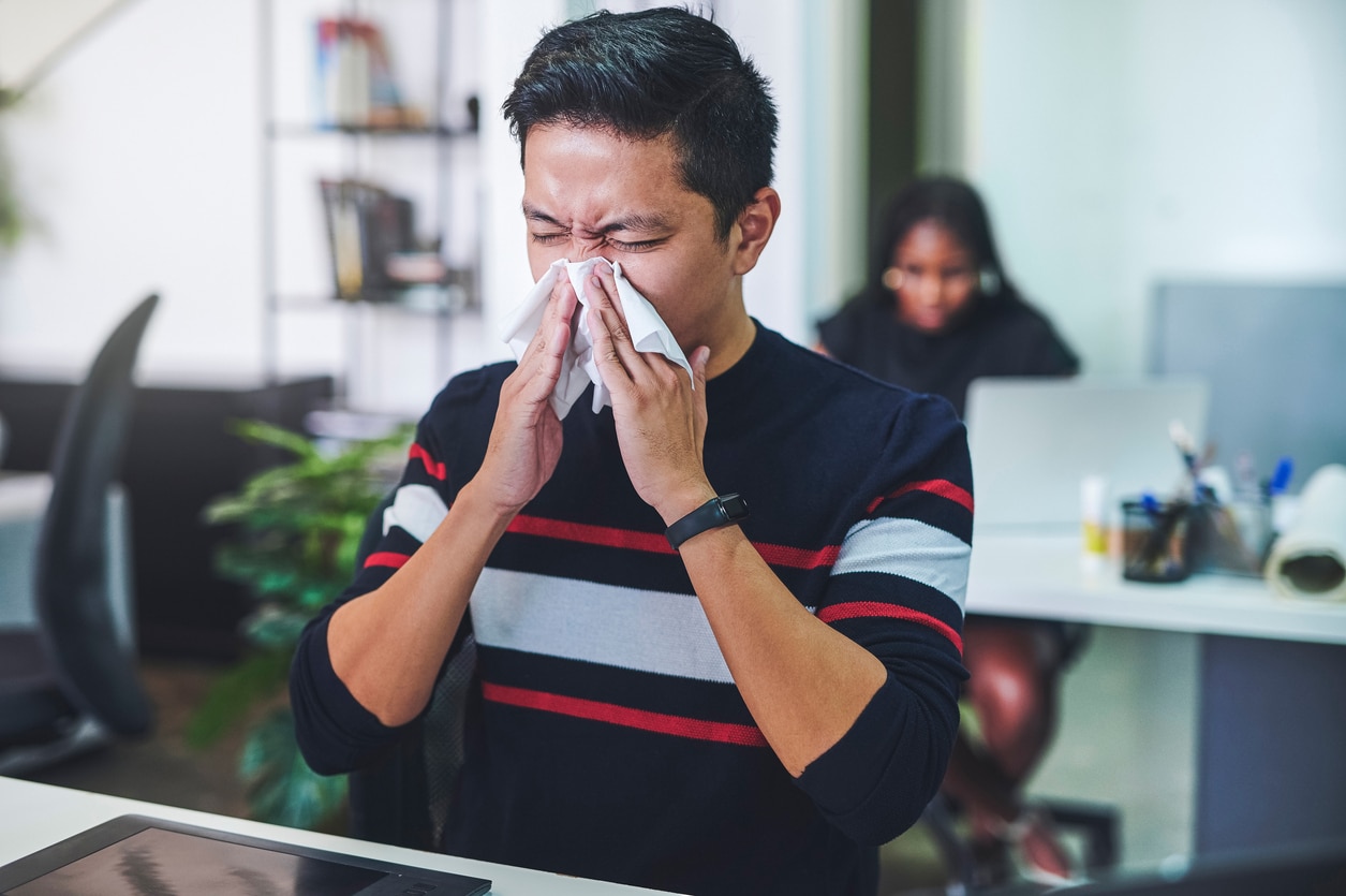 Shot of a young man blowing his nose